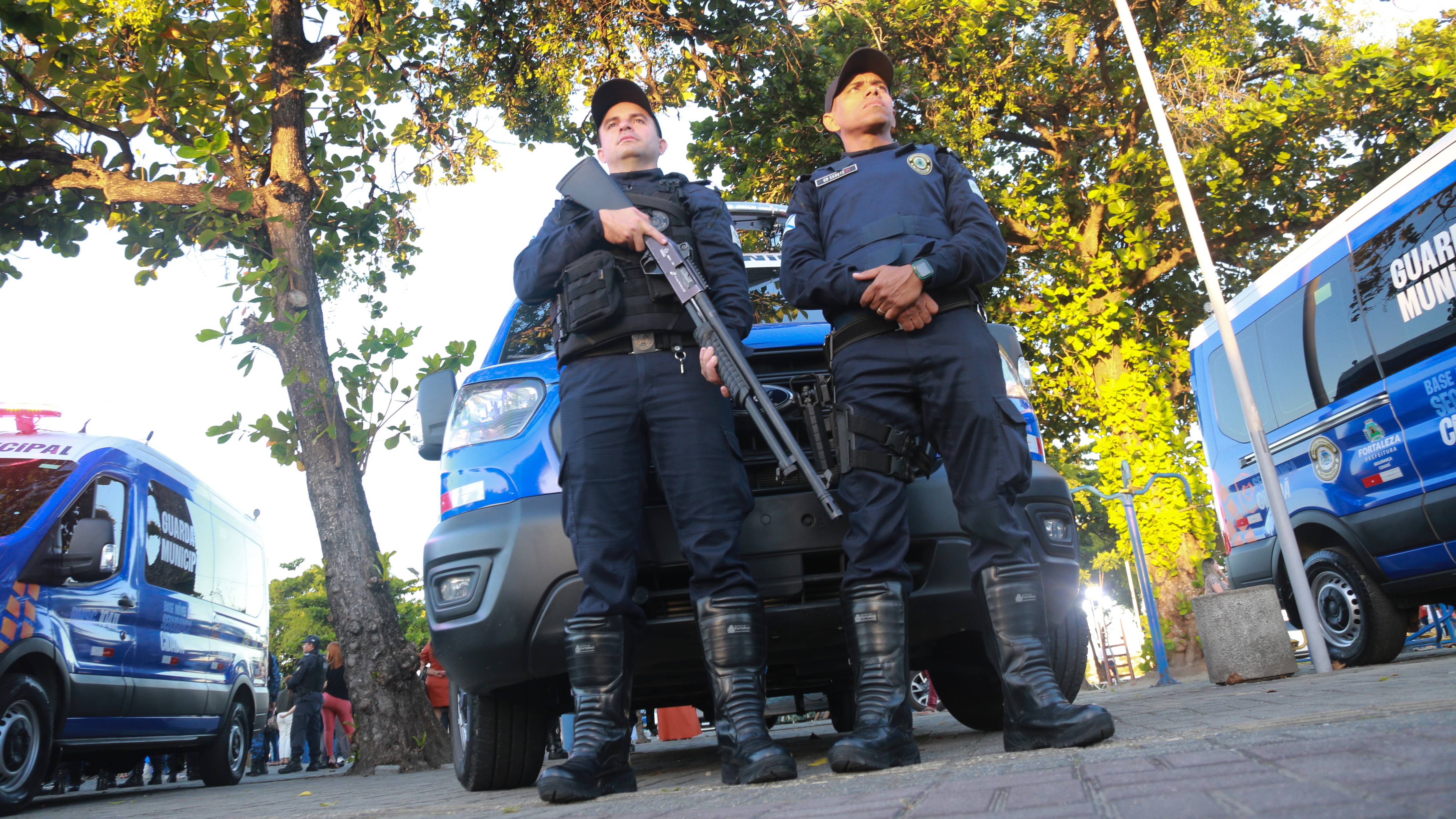 dois guardas municipais na frente de uma van do órgão